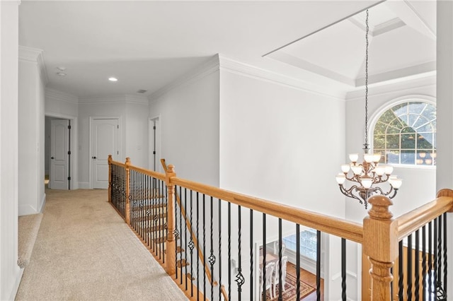 hall featuring ornamental molding, a chandelier, and light colored carpet