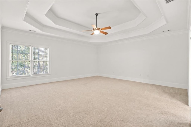 unfurnished room featuring carpet flooring, a raised ceiling, ornamental molding, and ceiling fan