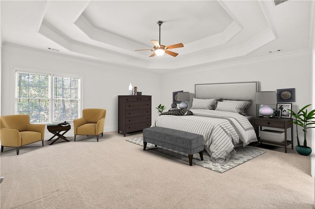 carpeted bedroom with crown molding, a tray ceiling, and ceiling fan