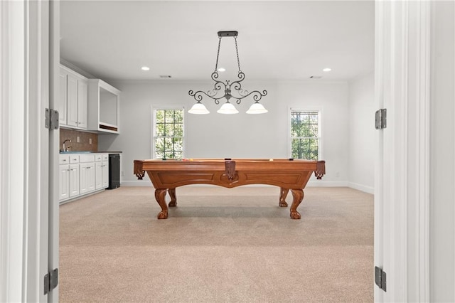 recreation room featuring ornamental molding, light colored carpet, and plenty of natural light