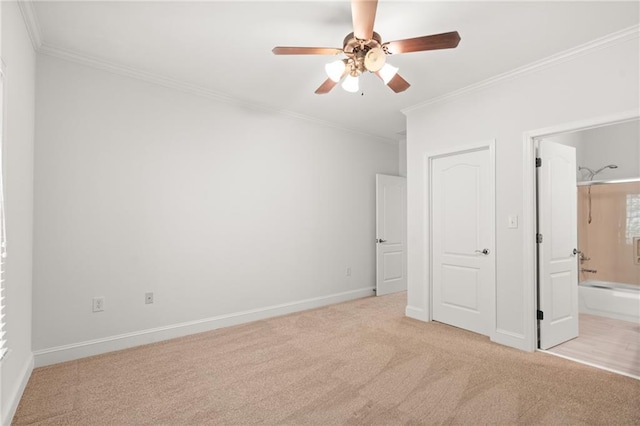 unfurnished bedroom featuring connected bathroom, crown molding, light carpet, and ceiling fan