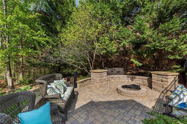 view of patio with an outdoor living space with a fire pit