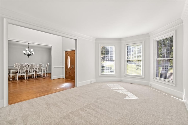 unfurnished room with crown molding, hardwood / wood-style flooring, and an inviting chandelier