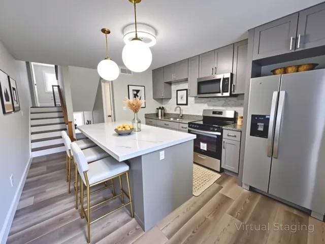 405 Fairburn Rd SW Unit 231, Atlanta, GA 30331 - kitchen featuring stainless steel appliances, gray cabinets, a kitchen island, and wood finished floors