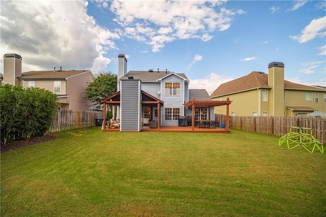 back of house featuring a yard, a chimney, a fenced backyard, and a wooden deck