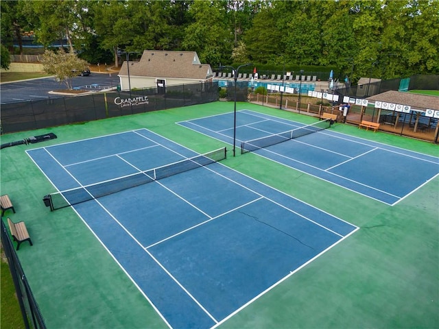 view of sport court featuring a community pool and fence