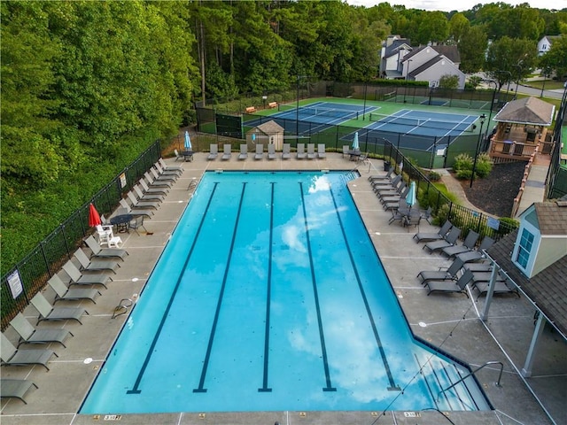 pool with a tennis court and fence