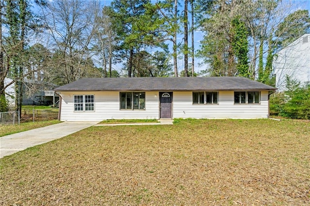ranch-style house with concrete driveway, a front yard, and fence