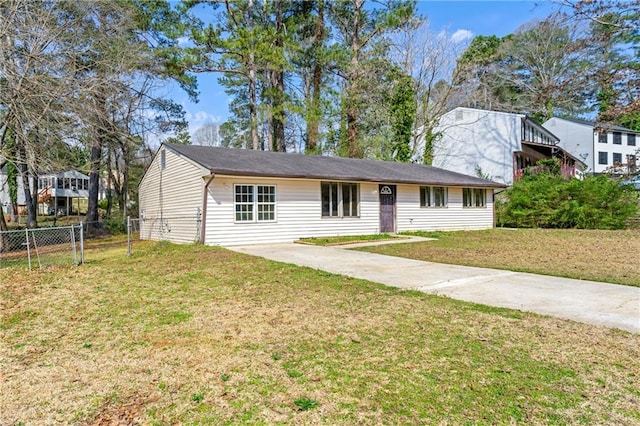 view of front of property featuring driveway, a front lawn, and fence