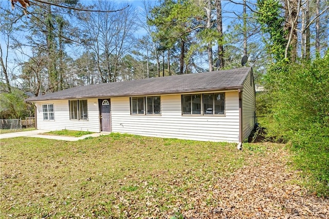 ranch-style house featuring a front yard and fence