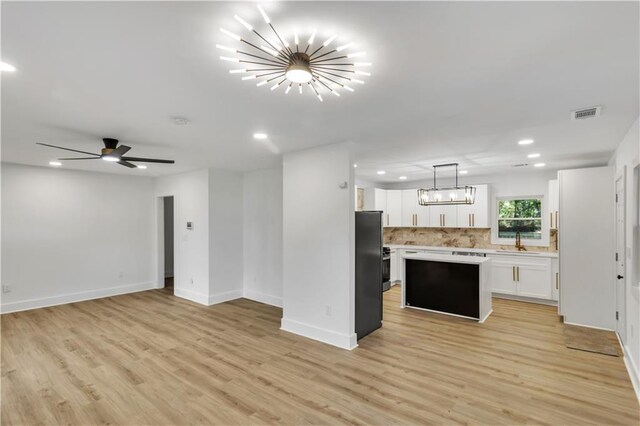 kitchen with a center island, light countertops, visible vents, open floor plan, and a sink