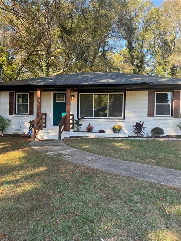 view of front facade with crawl space, brick siding, and a front lawn