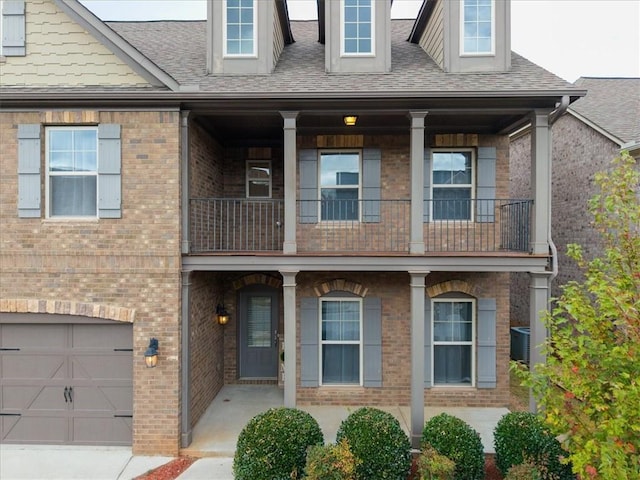 view of property with central AC unit, a garage, and a balcony