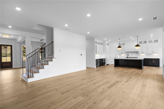 living room featuring light wood-type flooring and sink