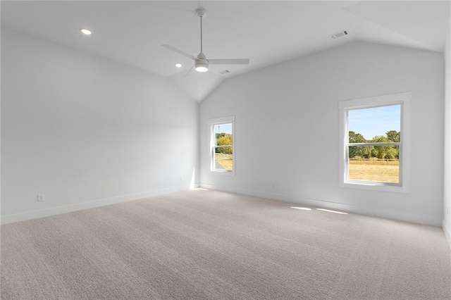 carpeted empty room with a wealth of natural light, ceiling fan, and lofted ceiling