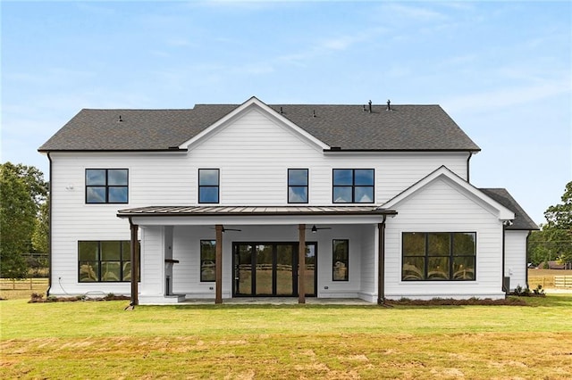 back of property featuring a yard and ceiling fan