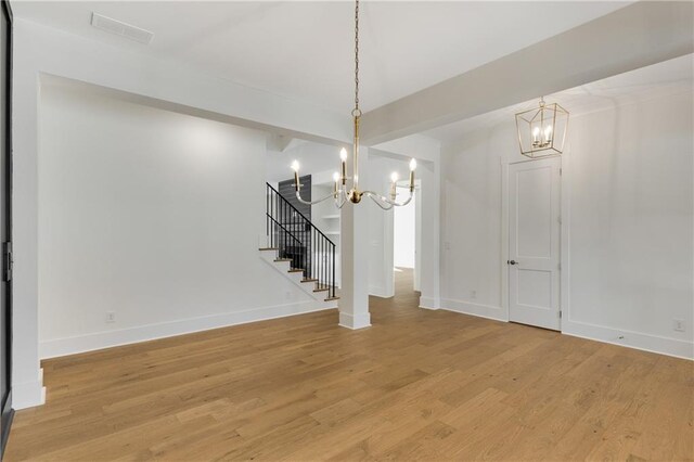 unfurnished dining area featuring hardwood / wood-style floors and an inviting chandelier