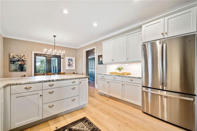 kitchen with ornamental molding, stainless steel fridge, light wood-style flooring, and tasteful backsplash