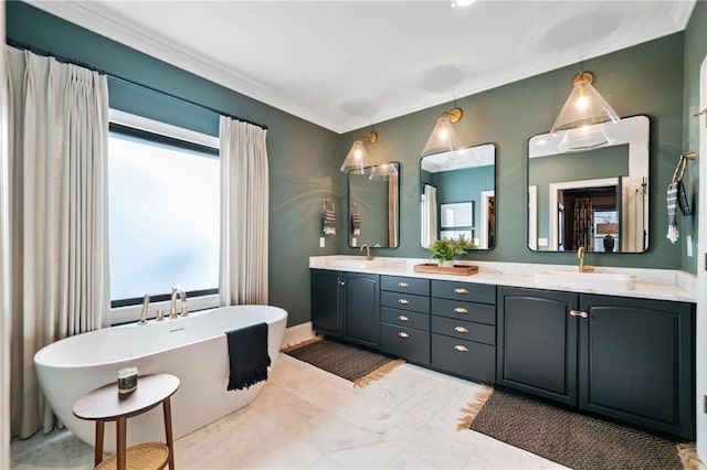 full bath with ornamental molding, a freestanding tub, and a sink