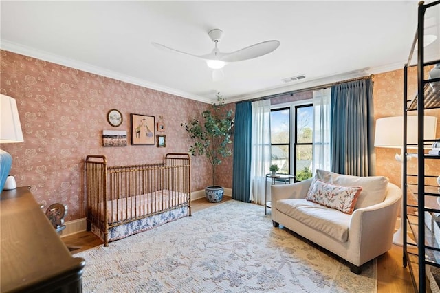 bedroom with wallpapered walls, baseboards, visible vents, and wood finished floors