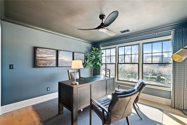 office featuring a ceiling fan, a wealth of natural light, visible vents, and wood finished floors