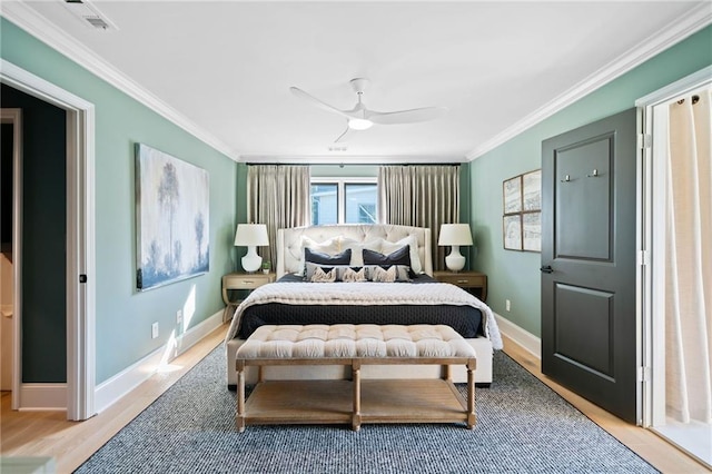 bedroom featuring crown molding, visible vents, ceiling fan, wood finished floors, and baseboards