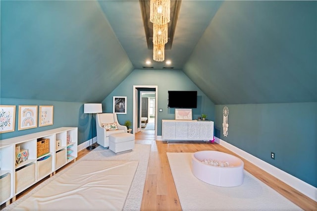 bedroom with lofted ceiling, wood finished floors, and baseboards