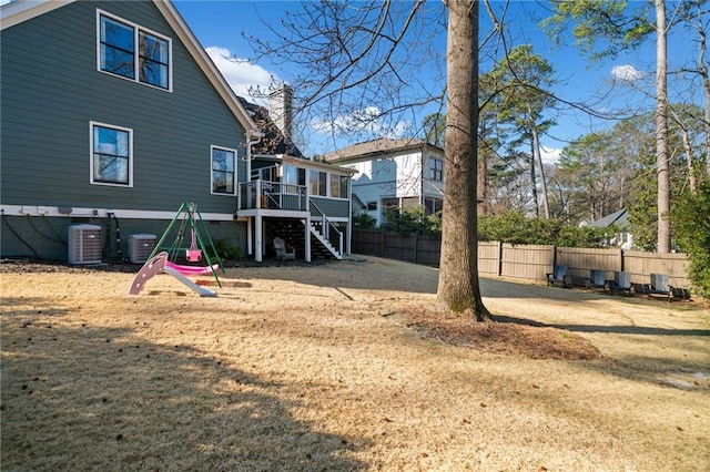 view of yard with central air condition unit, stairs, fence, and a wooden deck