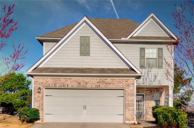 traditional home with a garage, brick siding, and driveway