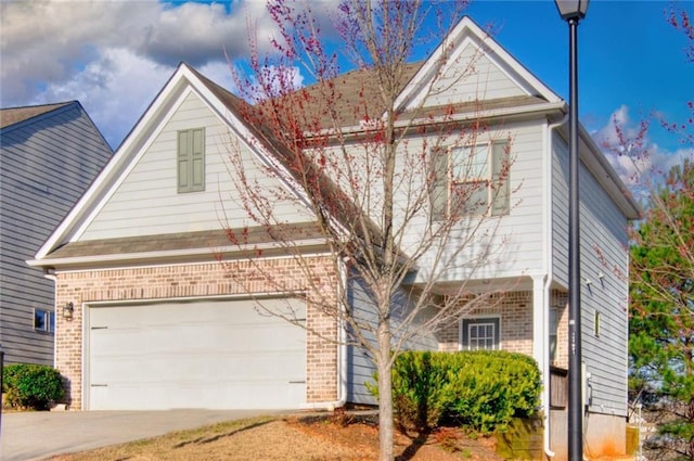 traditional-style home with a garage, concrete driveway, and brick siding