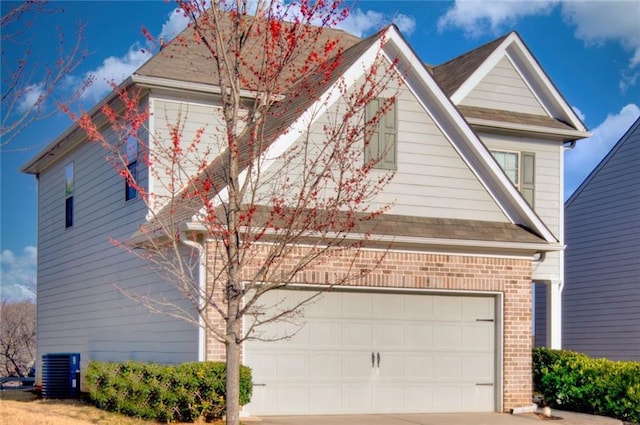 view of front of property featuring central air condition unit, an attached garage, concrete driveway, and brick siding