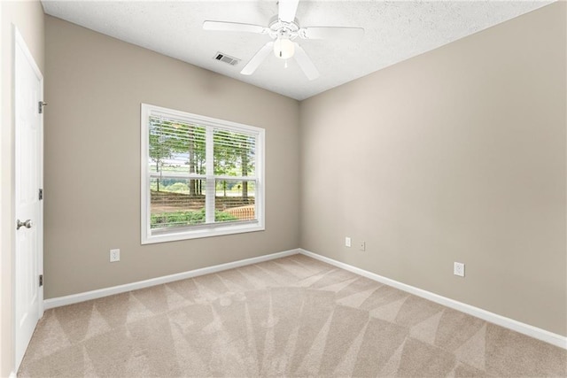 carpeted empty room with a textured ceiling and ceiling fan