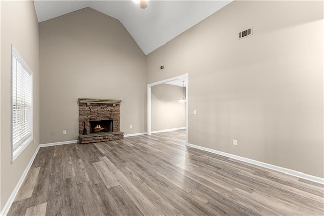 unfurnished living room with a fireplace, high vaulted ceiling, and light hardwood / wood-style flooring