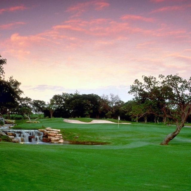 view of community with view of golf course and a yard