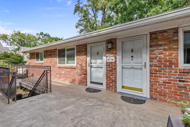 view of exterior entry with a patio area