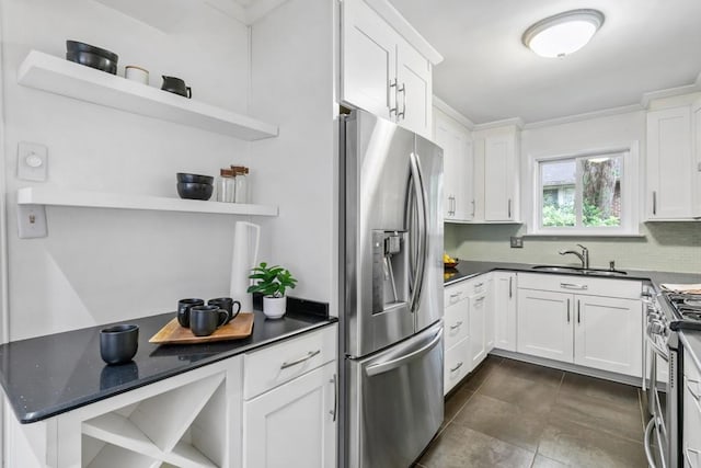 kitchen with appliances with stainless steel finishes, sink, white cabinets, backsplash, and dark tile patterned floors