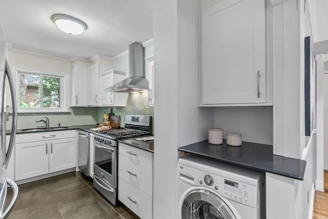 kitchen featuring washer / clothes dryer, white cabinetry, sink, stainless steel appliances, and wall chimney range hood