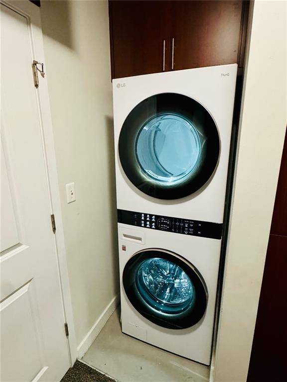 400 W Peachtree St NW Unit 3412, Atlanta, GA 30308 - washroom featuring stacked washer and clothes dryer and baseboards