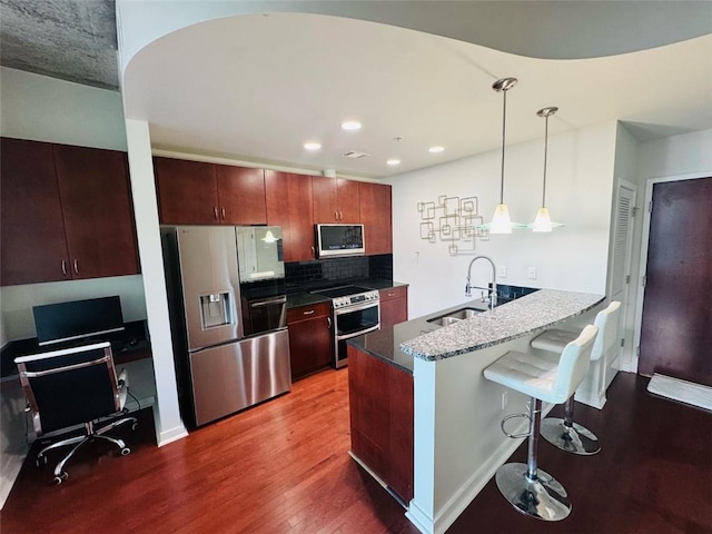 400 W Peachtree St NW Unit 3412, Atlanta, GA 30308 - kitchen featuring appliances with stainless steel finishes, a kitchen bar, wood finished floors, decorative backsplash, and pendant lighting
