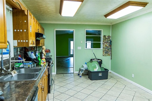 83 Manning Lake Rd, Rome, GA 30165 - kitchen with crown molding, ventilation hood, light tile patterned floors, stainless steel gas range oven, and brown cabinetry