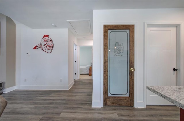 hallway with attic access, baseboards, and dark wood-type flooring