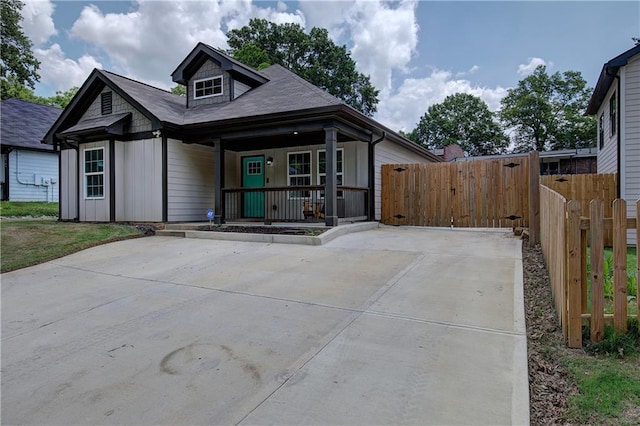 view of front of house with a porch, fence, and board and batten siding