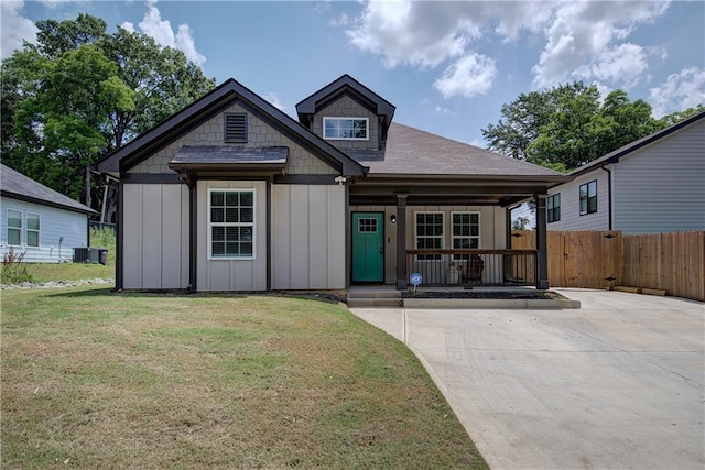 view of front facade with a porch, board and batten siding, a front yard, and cooling unit
