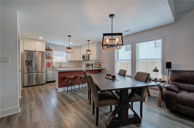 dining area featuring recessed lighting, visible vents, an inviting chandelier, wood finished floors, and baseboards