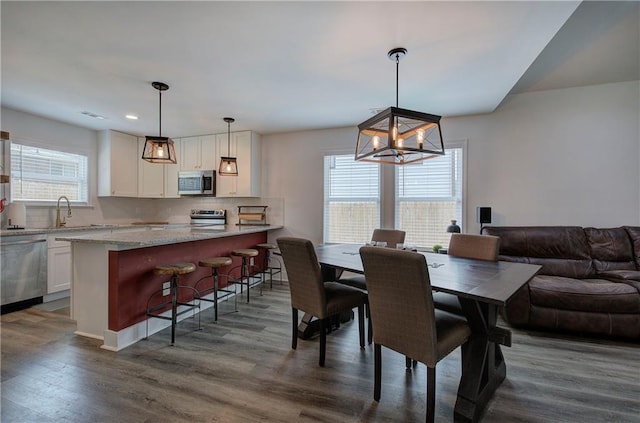 dining area with dark wood-type flooring and a notable chandelier