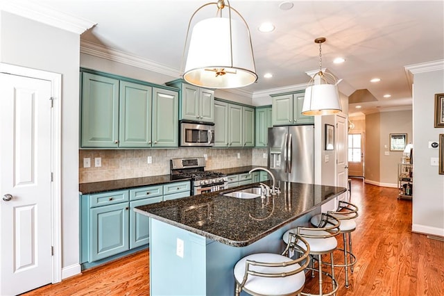 kitchen featuring light wood-type flooring, a sink, appliances with stainless steel finishes, and backsplash