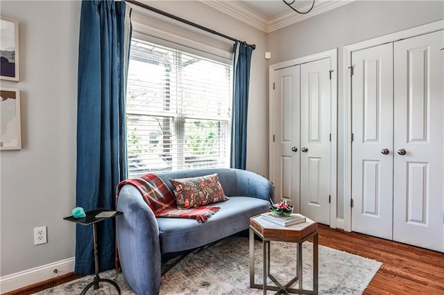 sitting room with crown molding, baseboards, and wood finished floors