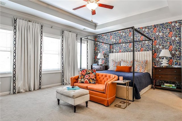 carpeted bedroom featuring baseboards, ornamental molding, and a raised ceiling