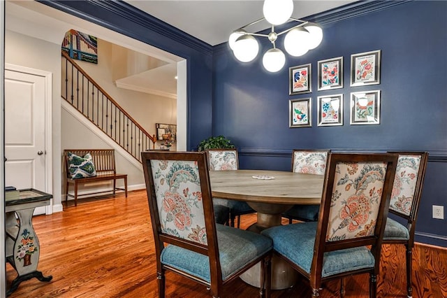 dining area with crown molding, wood finished floors, stairway, baseboards, and a chandelier