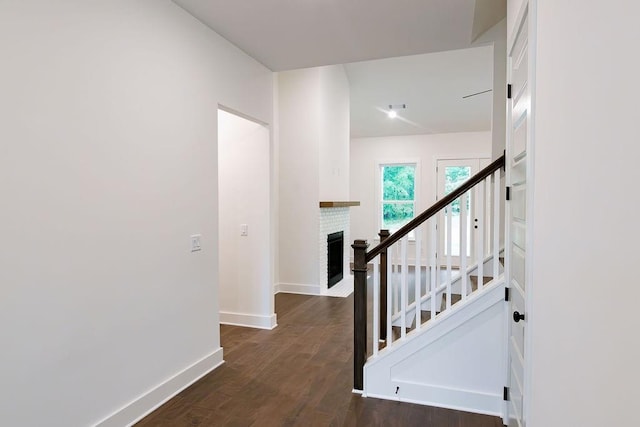 stairway with visible vents, a fireplace, baseboards, and wood finished floors